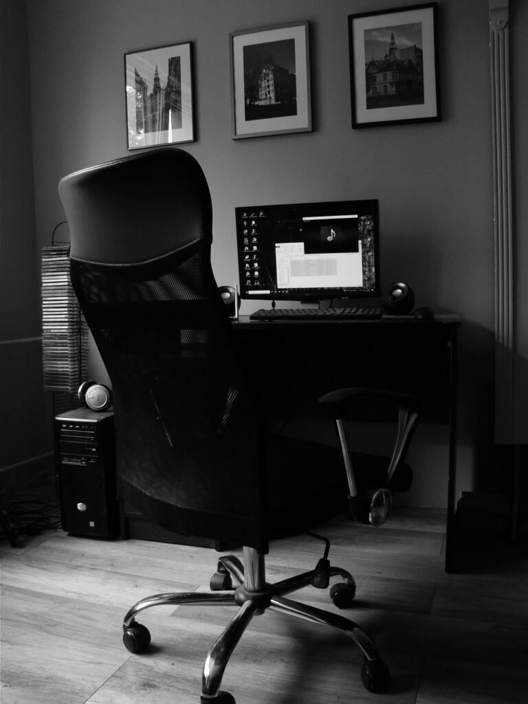 Black and white home office with desk, chair, and computer monitor on display.