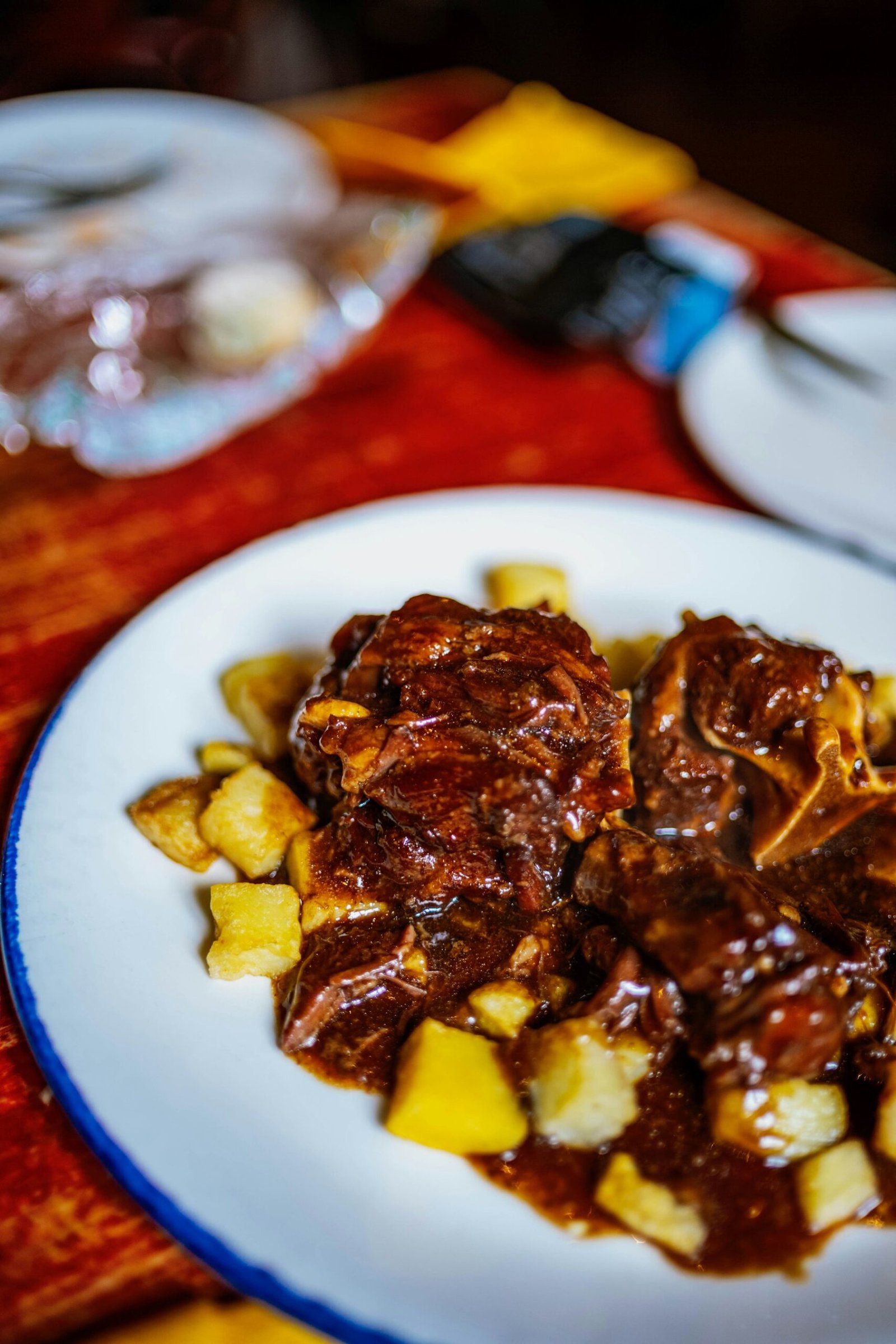 Plate of dark stewed meat with diced potatoes